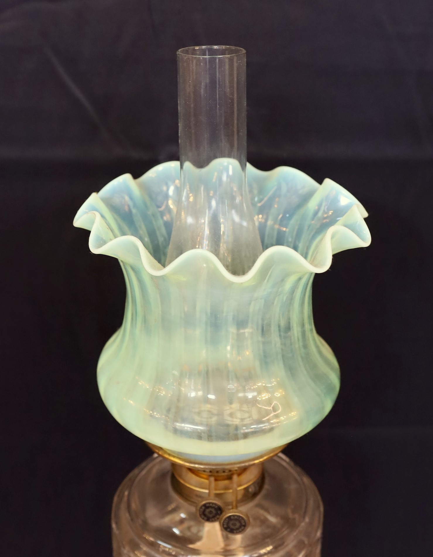 A late Victorian lacquered brass oil lamp with cut glass reservoir, Vaseline glass shade and flue, height overall 82cm